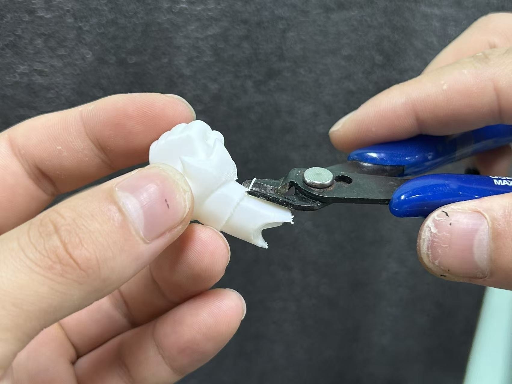 Close-up of trimming a resin 3D printed support nub using flush cutters.